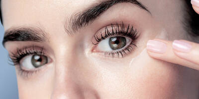 Lily Collins applying Lancome eye cream to her eye contour area