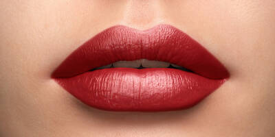 Cool toned red lipstick on a light fair skin tone in a cream finish