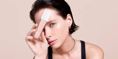 Woman with a fair skin tone with a dry skin type holding foundation bottle