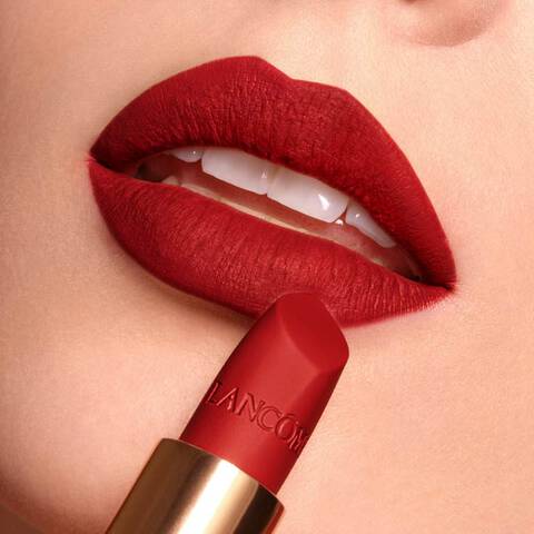 Woman with fair skin wearing and showing Lancome red lipstick