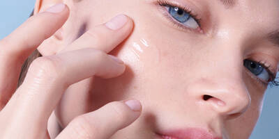 Woman applying skin barrier serum to fix her damaged skin barrier