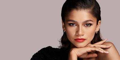 Zendaya wearing a bold orange-red lipstick shade.