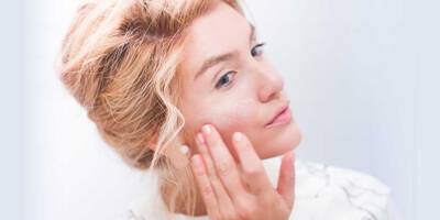 Woman showing how to apply facial skincare to care for the skin barrier.