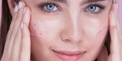 Woman practicing how to exfoliate face with the Lancome Rose Sugar Exfoliating Scrub