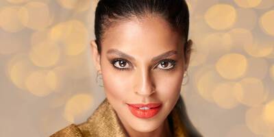 Model wearing a glam new year’s eve makeup look with a bronze smokey eye and red lip.