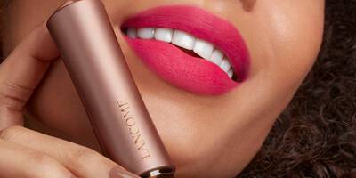 Close up of bright pink matte lipstick on a medium dark skin tone