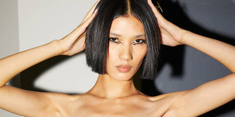 Model striking a pose wearing the futuristic cat eye makeup created using Lancome skincare and makeup