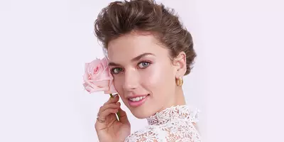 Woman with hair in updo wearing pretty soft natural makeup for wedding day.