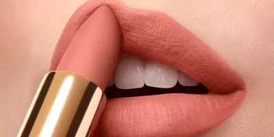 Woman applying pink nude lip color with a nude lipstick