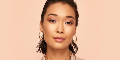 Rose Gold Glam Makeup Look with eyeshadow lip gloss and blush worn on a model with medium skin tone