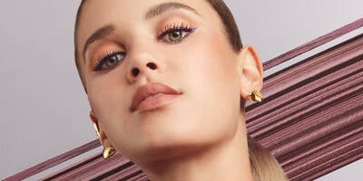 Caucasian woman wearing the Lancome eye makeup look in burgundy tones