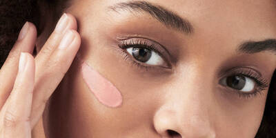 Woman applying a face primer onto skin for longer lasting makeup