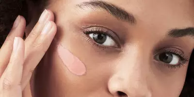 Woman applying a face primer onto skin for longer lasting makeup