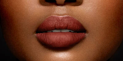 Warm toasted caramel brown lipstick shade worn on a dark skin tone