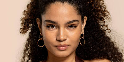Woman wearing a glowy makeup look with glowing foundation, serum concealer, and highlighter