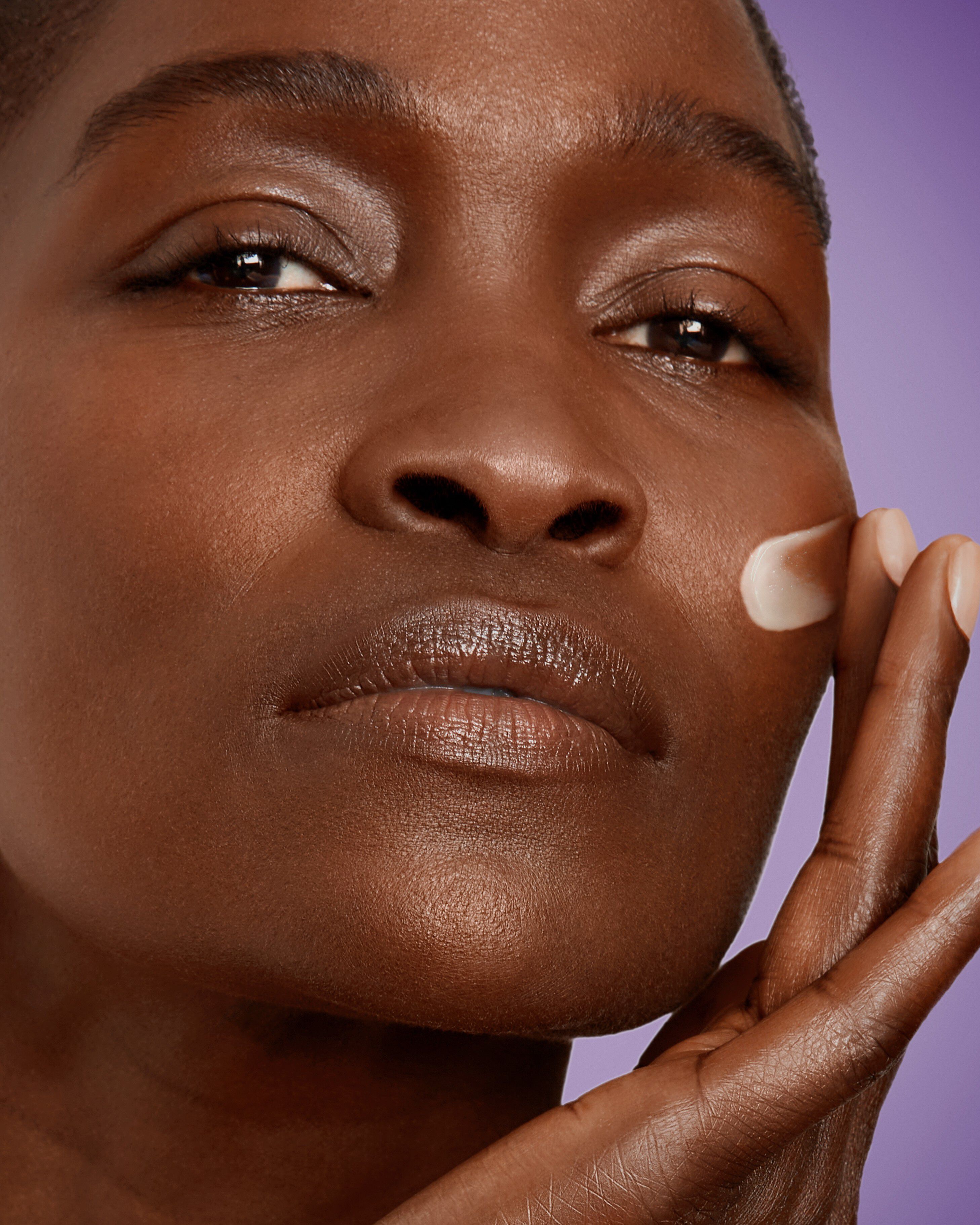 Beauty Visual - A woman is applying Renergie Serum on her face