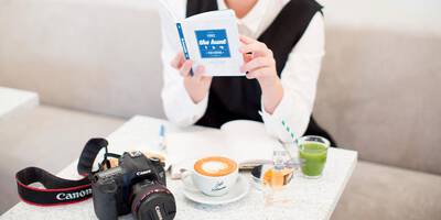Woman studying book on how to do makeup for good pictures and selfies.